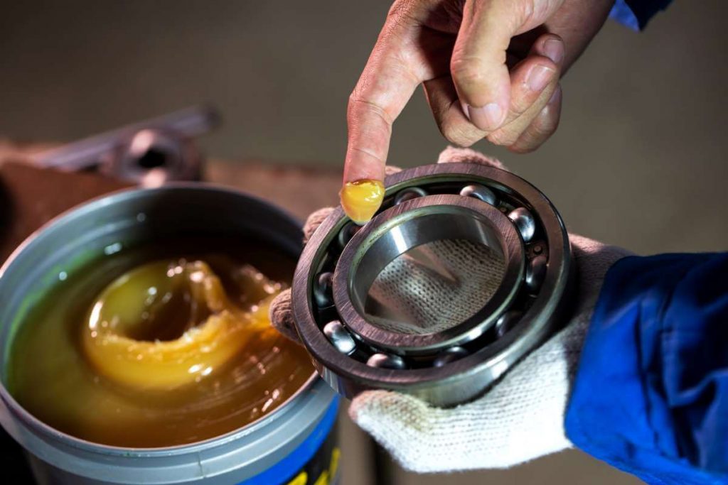 Hombre aplicando lubricante industrial-asteclub