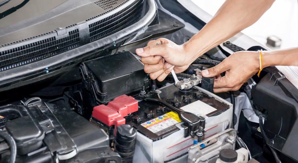 Hombre reparando la batería del automóvil-asteclub