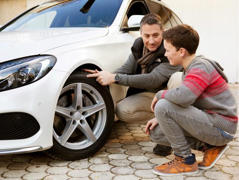 Hombre e hijo inspeccionando el automóvil antes de un viaje blog-asteclub