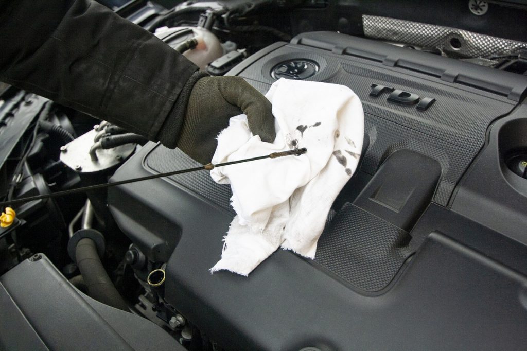 persona examinando el aceite automotriz